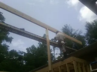Carpenter setting a ridge beam over a new addition frame — Ice Dam Removal by Roofing Brothers in Macy