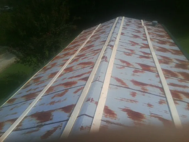 Rusted metal roof panels with new wood purlins before replacement — Storm Damage Roof Repair in Macy by Roofing Brothers