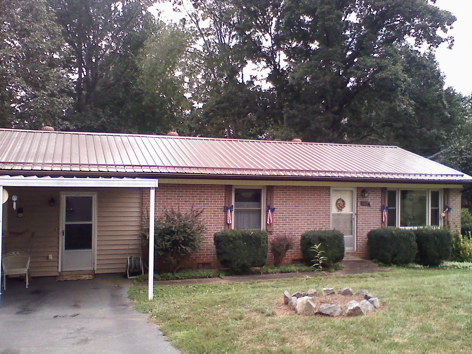 Bronze metal roof and carport on a brick ranch home — Roof Repair work by our crew in Macy